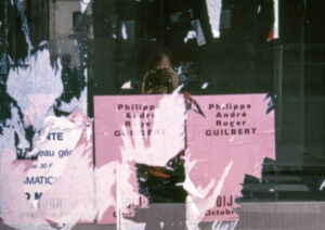 affiche rose décollée sur une vitre avec reflet